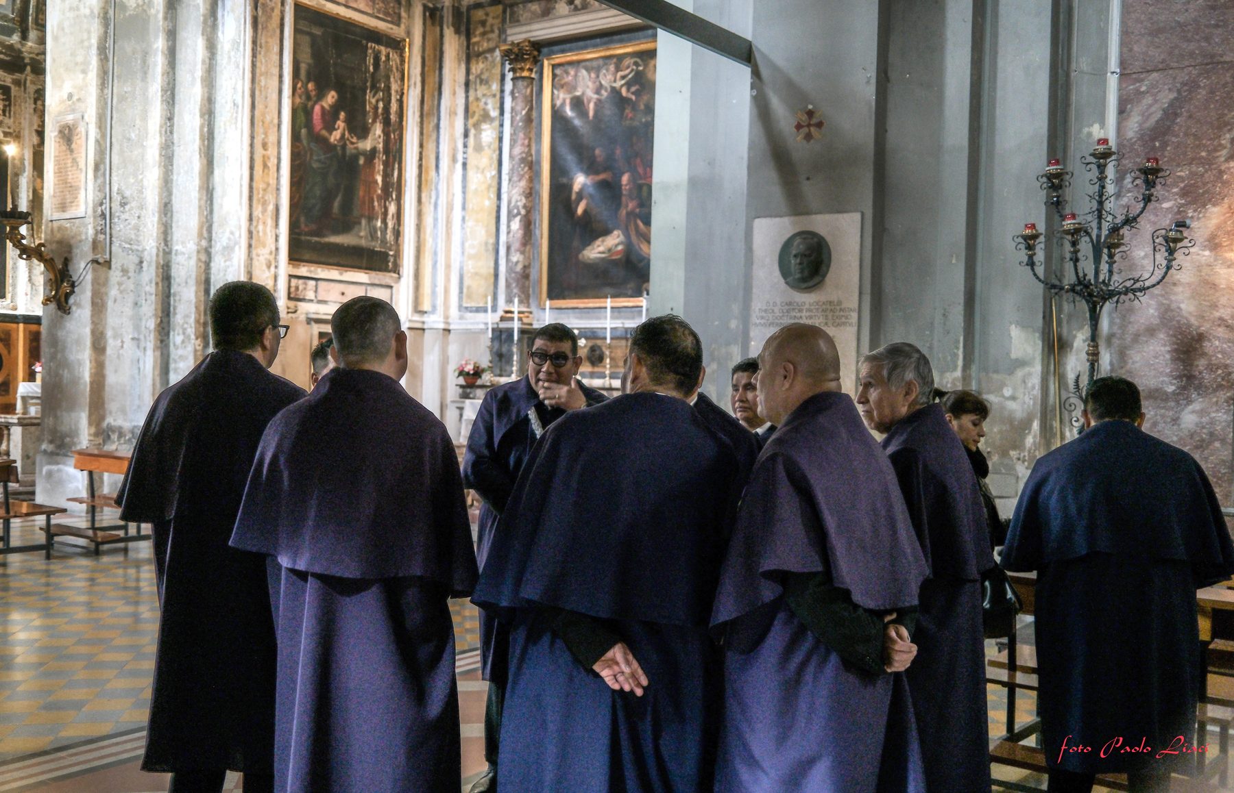 Hermanos in abito viola raccolti insieme all'interno della chiesa